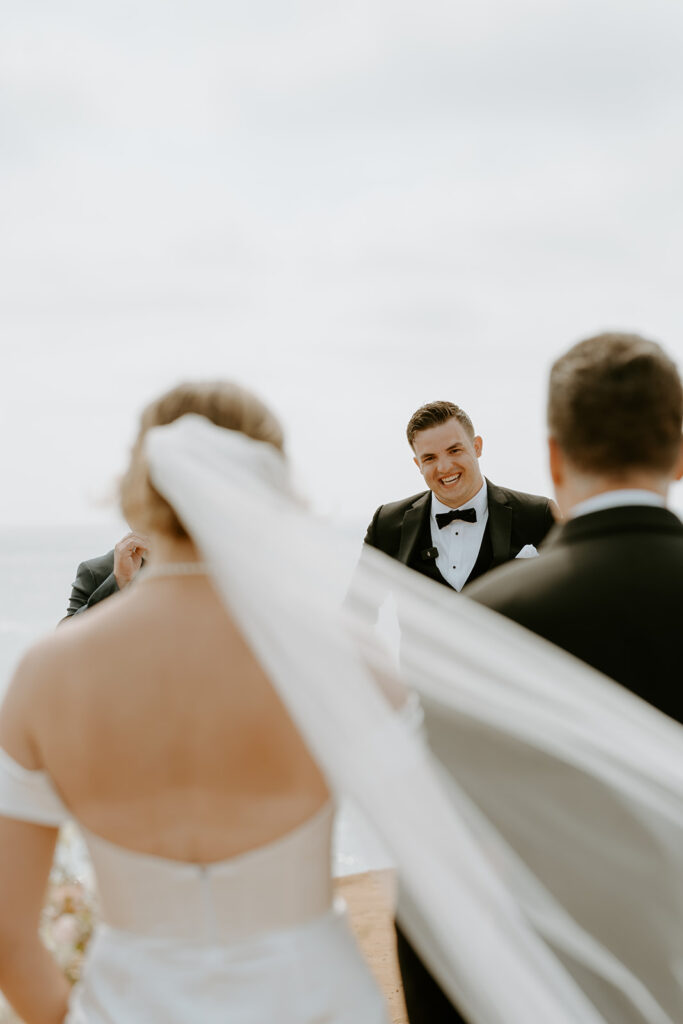 bride walking down the aisle at beach wedding at sunset cliffs