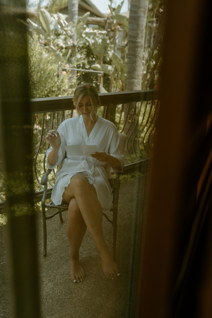 bride reading letter from groom on balcony patio