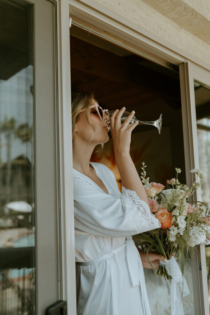 bride in pre-wedding attire enjoying a drink