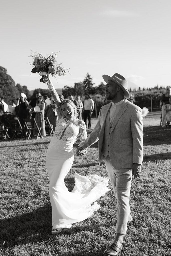 bride and groom leaving orchard wedding ceremony hand in hand