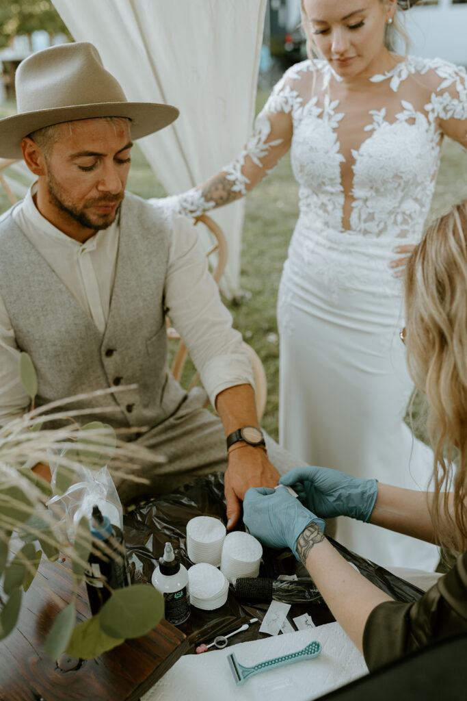 bride and groom getting micro tattoos during wedding reception