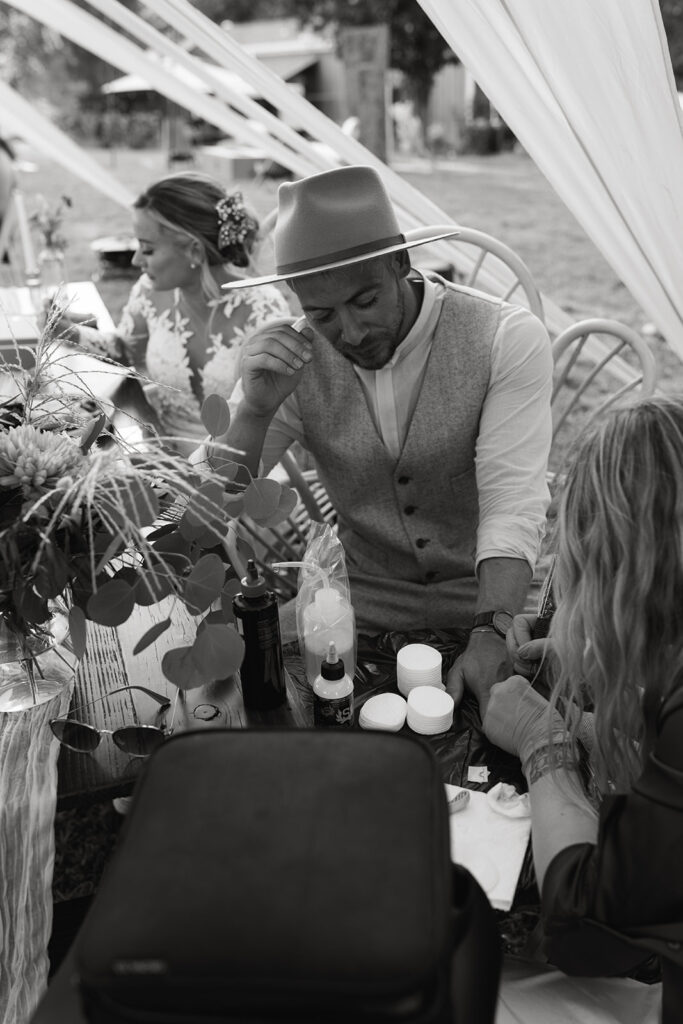 bride and groom getting micro tattoos during wedding reception