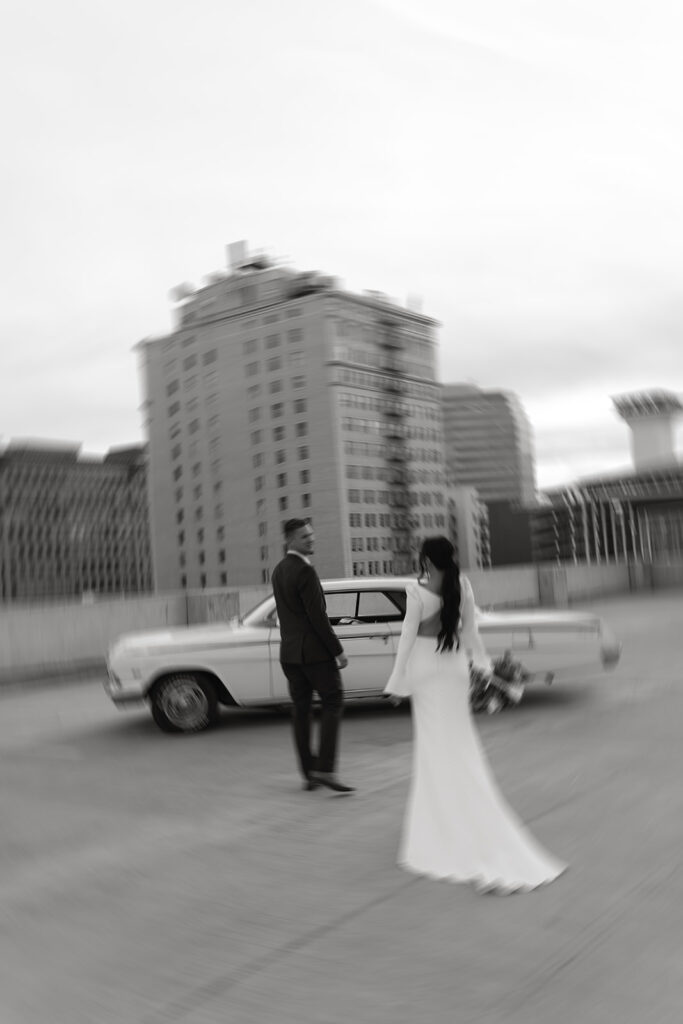 bride and groom with classic car on the rooftop after downtown elopement ceremony