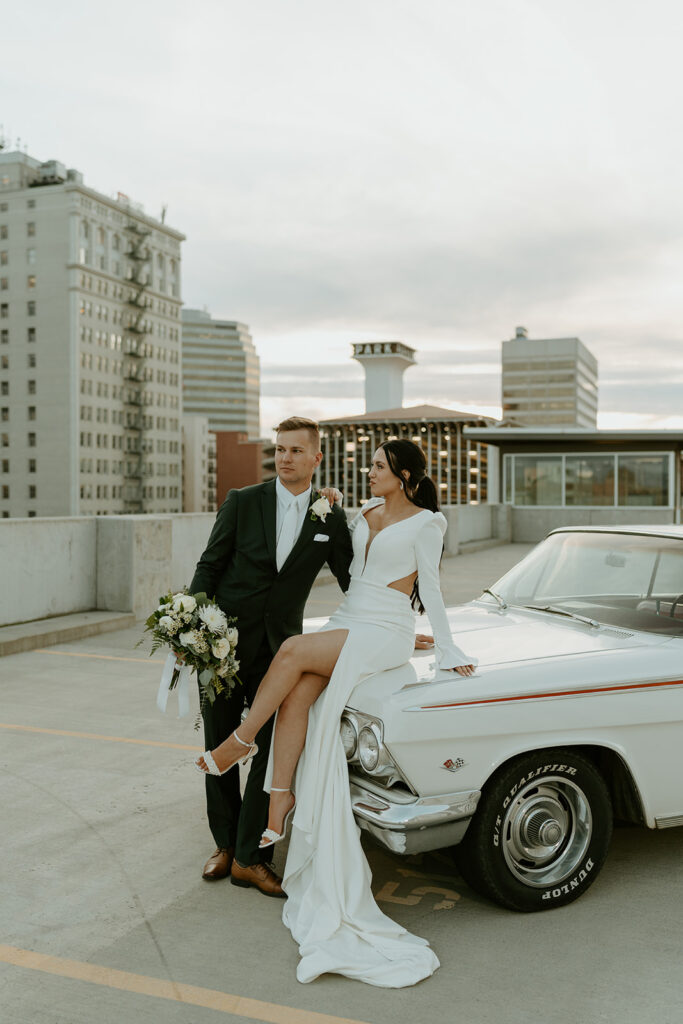 bride and groom with classic car on the rooftop after downtown elopement ceremony