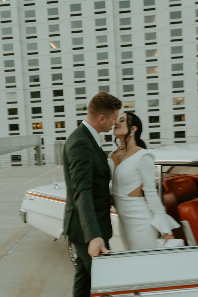 bride and groom with classic car on the rooftop after downtown elopement ceremony