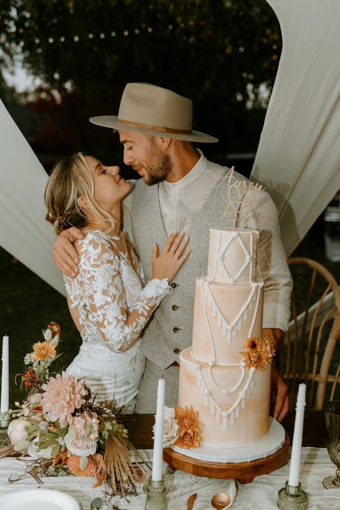 bride and groom cutting boho wedding cake