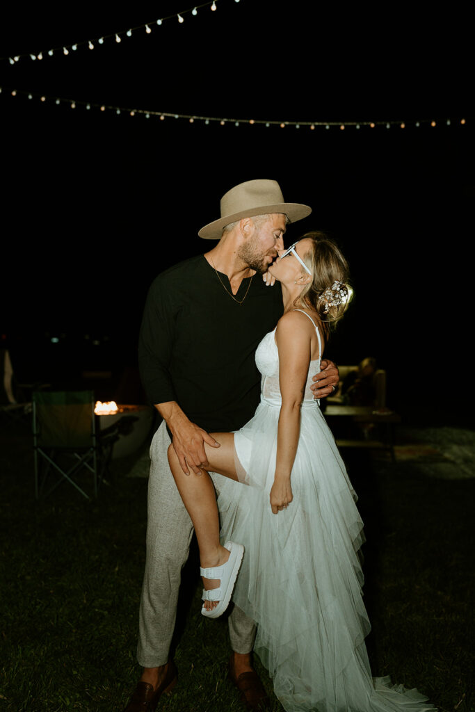 bride and groom kissing at their wedding reception in the evening