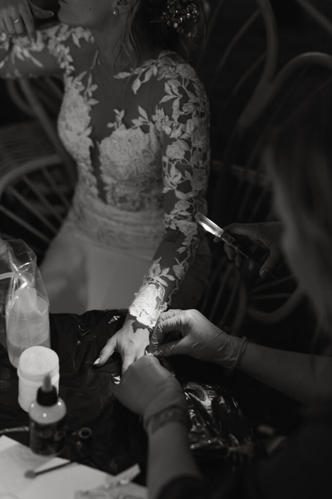 bride and groom getting micro tattoos during wedding reception