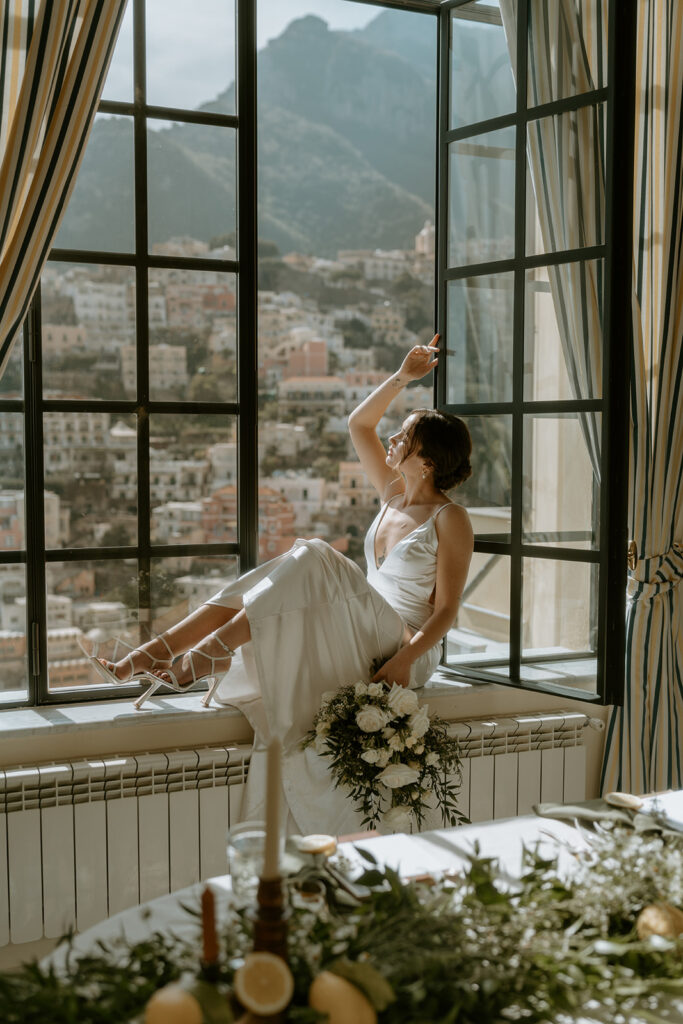 The bride in a silky wedding gown, sitting amidst lemon-inspired decor.