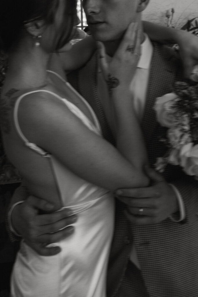 editorial style shot of the bride and groom hugging close-up