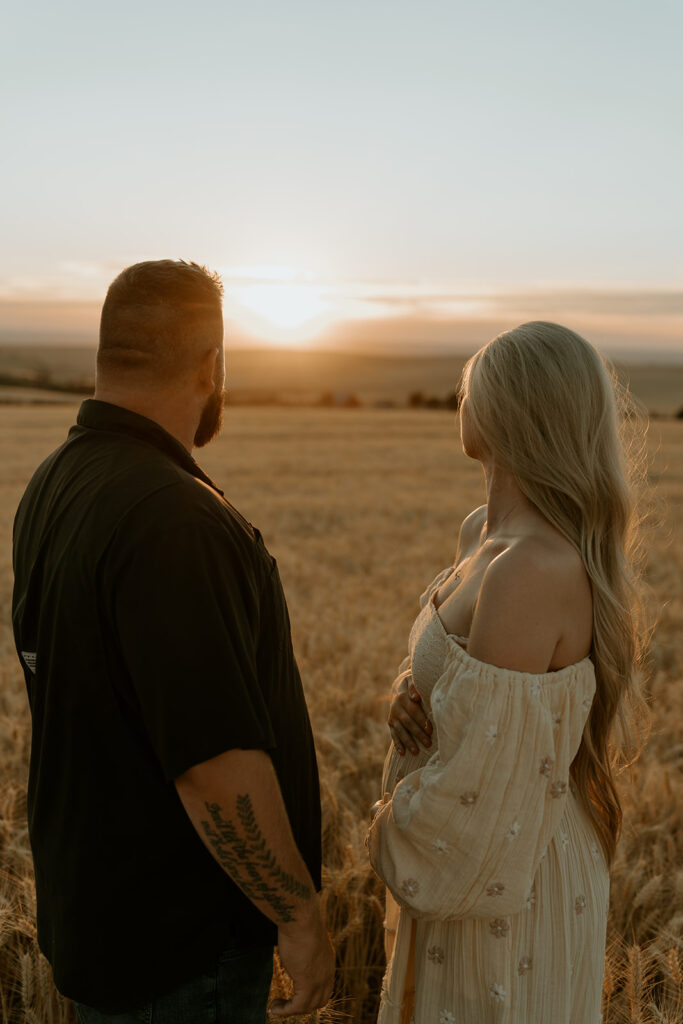 Haley and Tate share a tender moment, the setting sun creating a romantic backdrop for their pregnancy reveal photo shoot.